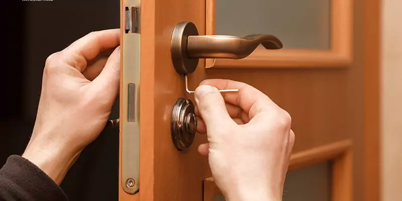 Close-up of door lock maintenance and screw adjustment to fix sticking doors during home repair.